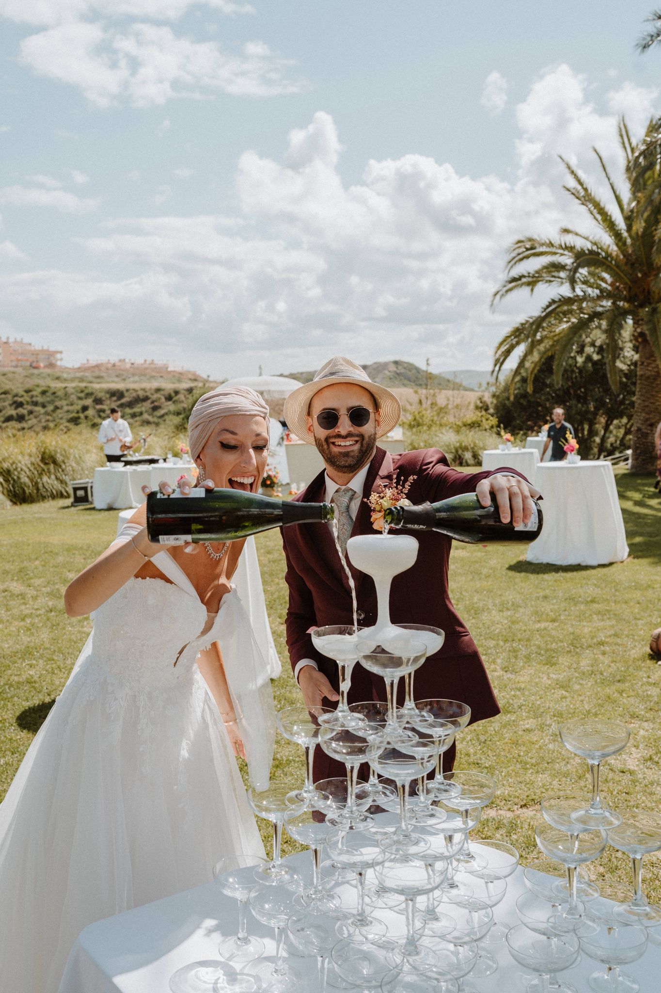 Charlotte y Emile sirviendo champán en su boda de lujo en Estepona, celebración elegante al aire libre en Cortijo Pedro Jiménez