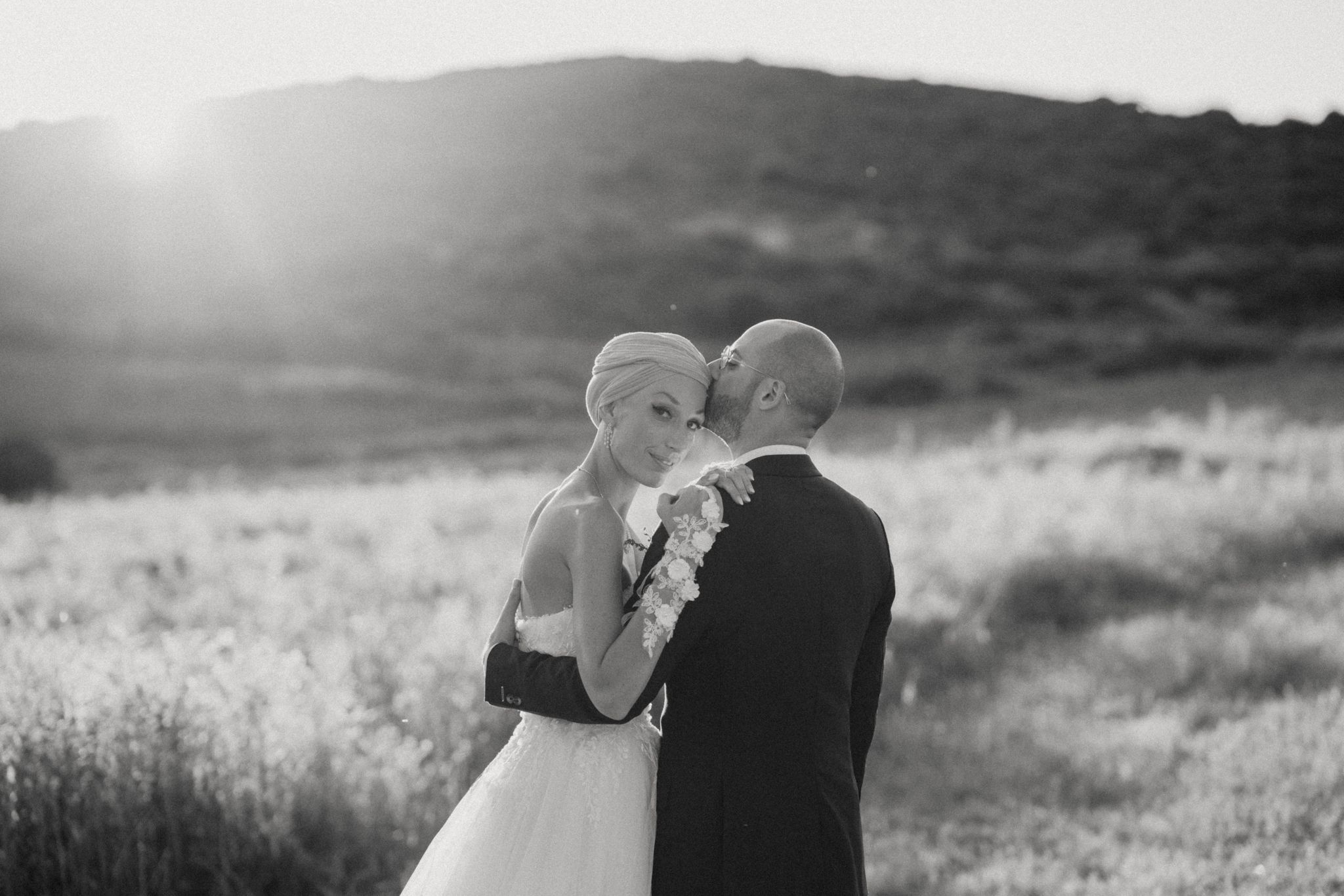 Charlotte y Emile abrazados al atardecer en su boda de lujo en Estepona, rodeados de naturaleza y luz dorada